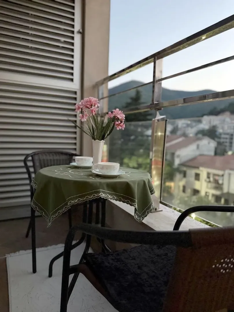 Furnished balcony with a table, chairs, and a view of the surroundings.