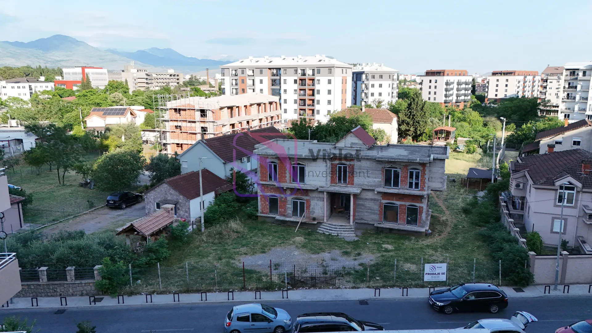 Pogled iz vazduha na kuću u izgradnji i okolno naselje sa zgradama.