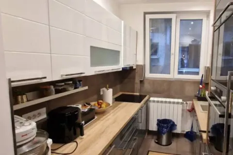 Manja opremljena kuhinja sa belim elementima i drvenom radnom pločom. - image 7
