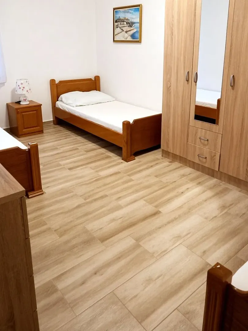 Furnished bedroom with a wooden bed and wardrobe.