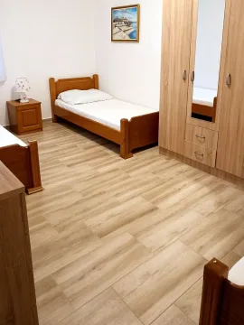 Furnished bedroom with a wooden bed and wardrobe. - image 3