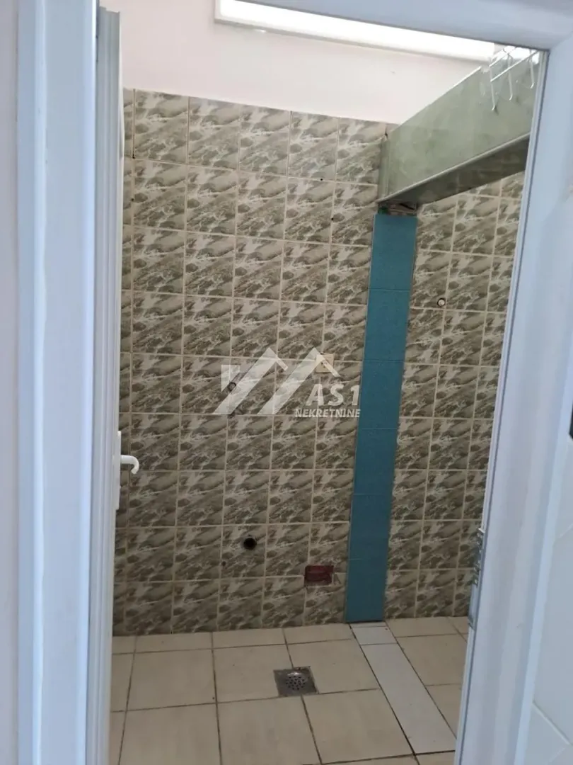 A view of part of a tiled bathroom with wall tiles and a floor drain.