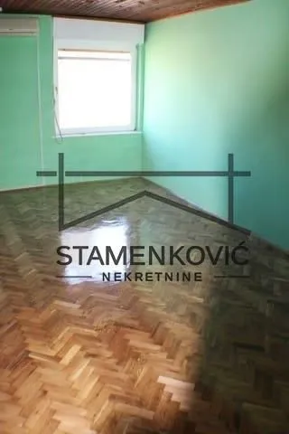 Empty room with parquet flooring and green walls.
