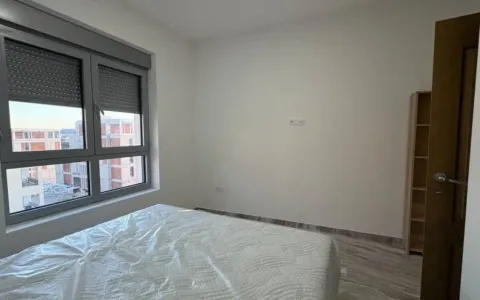 Prazna spavaća soba sa krevetom prekrivenim zaštitnom folijom i prozorom. - image 5