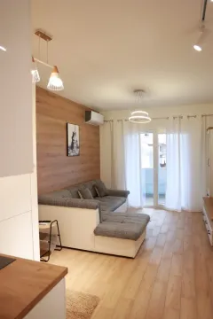 Living room with a corner sofa, wooden wall panel, and access to the terrace. - image 17