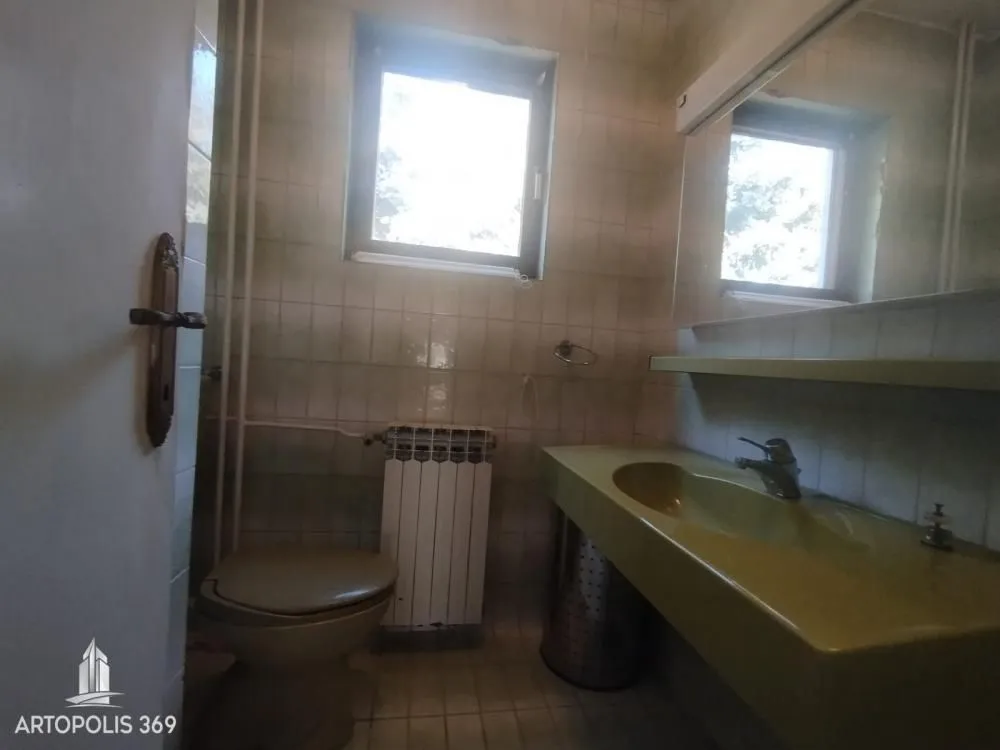 Manje kupatilo sa lavaboom, wc šoljom i prozorom.