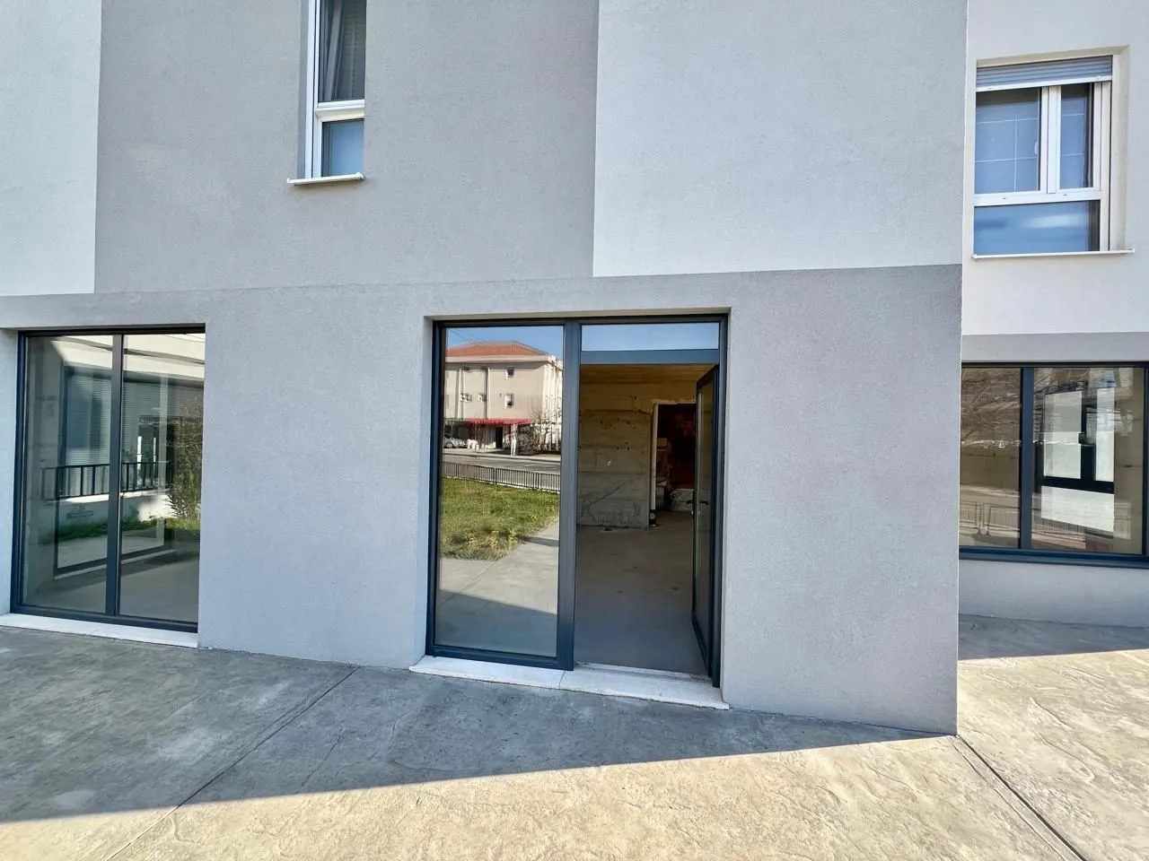 Exterior of a modern residential building with large glass surfaces and an entrance.