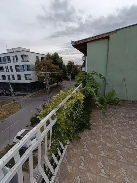 Terasa sa popločanim podom, metalnom ogradom i pogledom na ulicu i okolne zgrade. - image 27