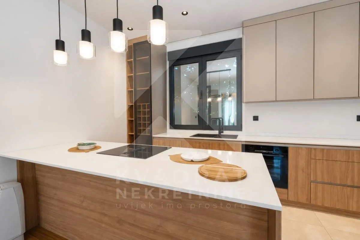 Modern kitchen with an island, built-in units, and pendant lights.