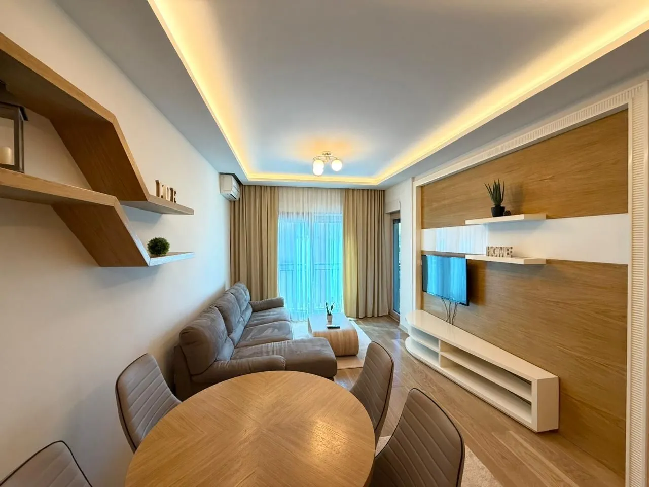 Living room with a sofa, TV, and dining table.