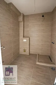 Nezavršeno kupatilo obloženo keramičkim pločicama u neutralnim tonovima sa tuš kabinom. - image 7