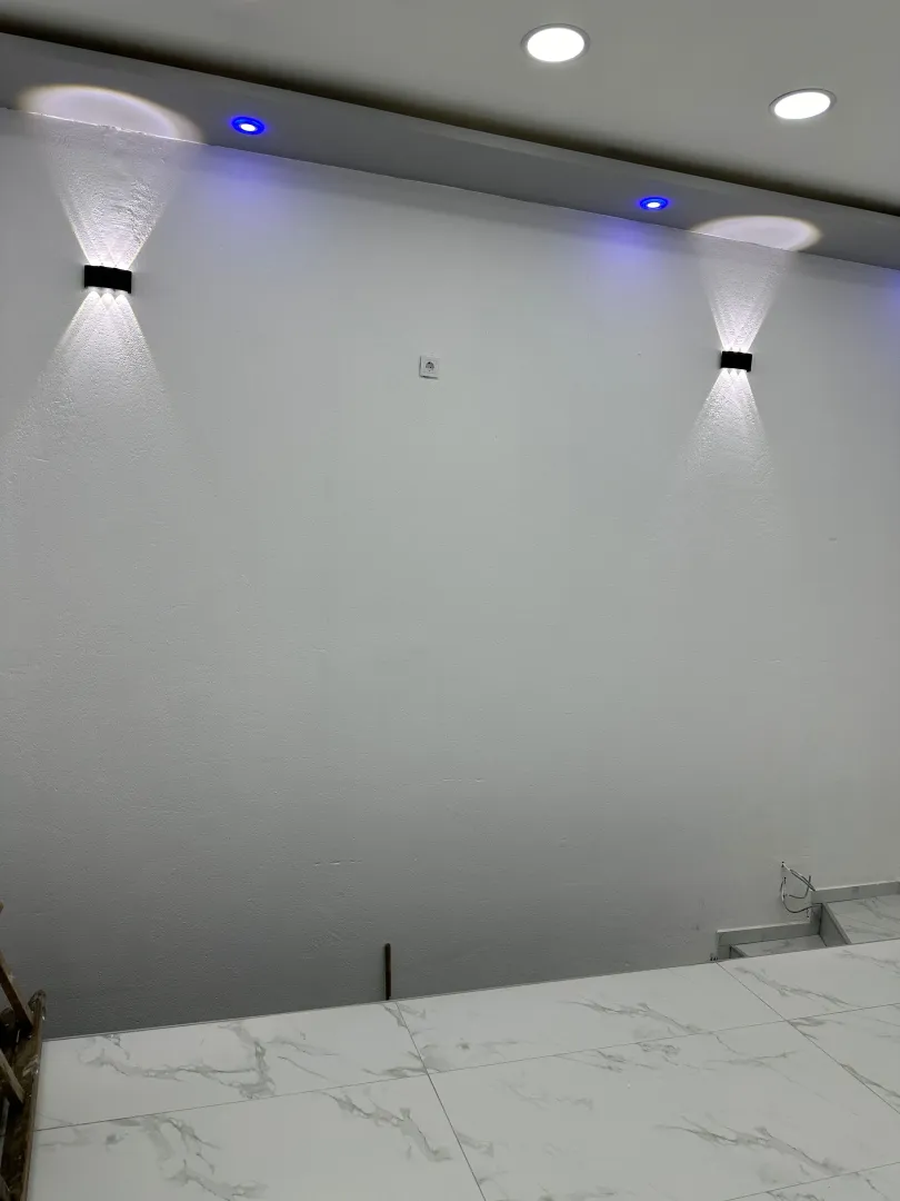 Empty white room with recessed lighting and ceramic tile flooring.