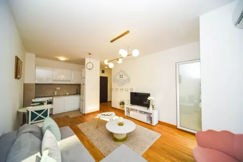 Living room with sofa, TV and kitchen in the background. - image 3