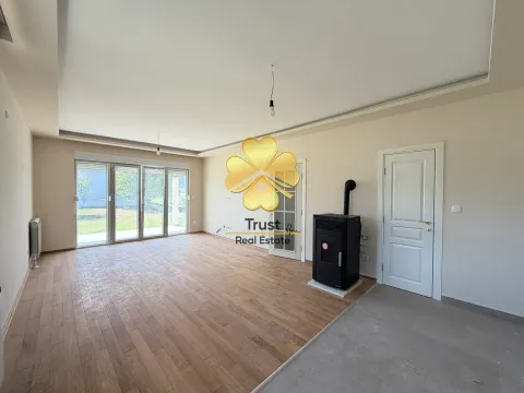 Empty living room with wooden flooring, pellet stove, and access to the yard. - image 5