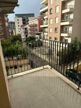 View from the balcony overlooking surrounding buildings and street. - image 10
