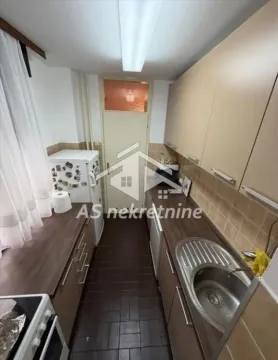 Smaller kitchen with wooden cabinets and a sink. - image 9