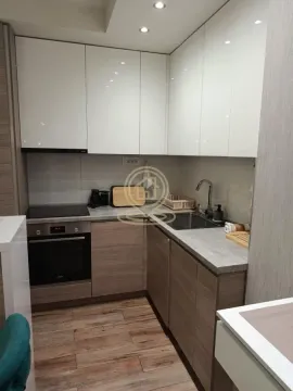 Small modern kitchen with white cabinets and built-in appliances. - image 9
