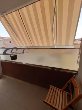Covered balcony with an awning and a wooden chair. - image 7