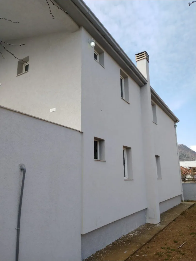 Exterior view of a two-story house with a light-colored facade.