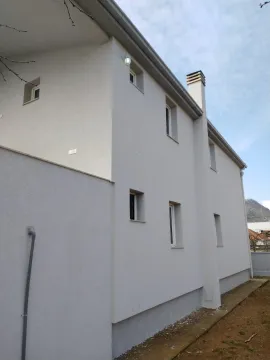 Exterior view of a two-story house with a light-colored facade. - image 5