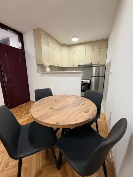 Dining area with a table and black chairs and a view of the kitchen. - image 5