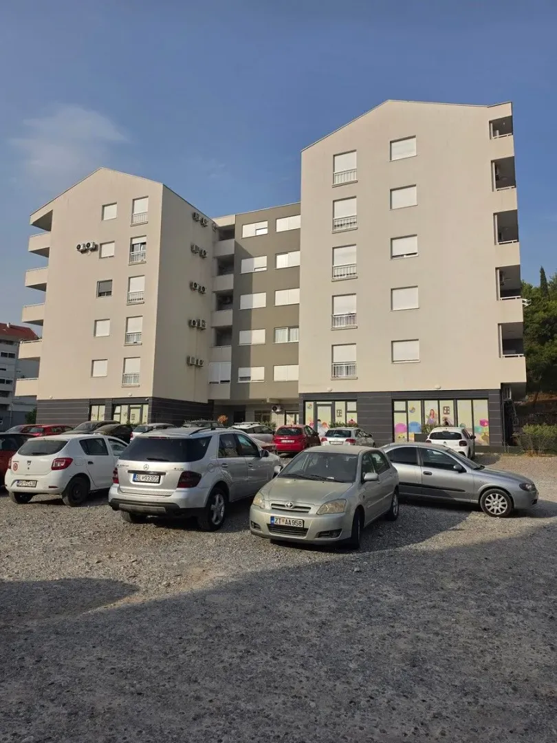 Exterior view of the residential building and the parking lot in front of the entrance.