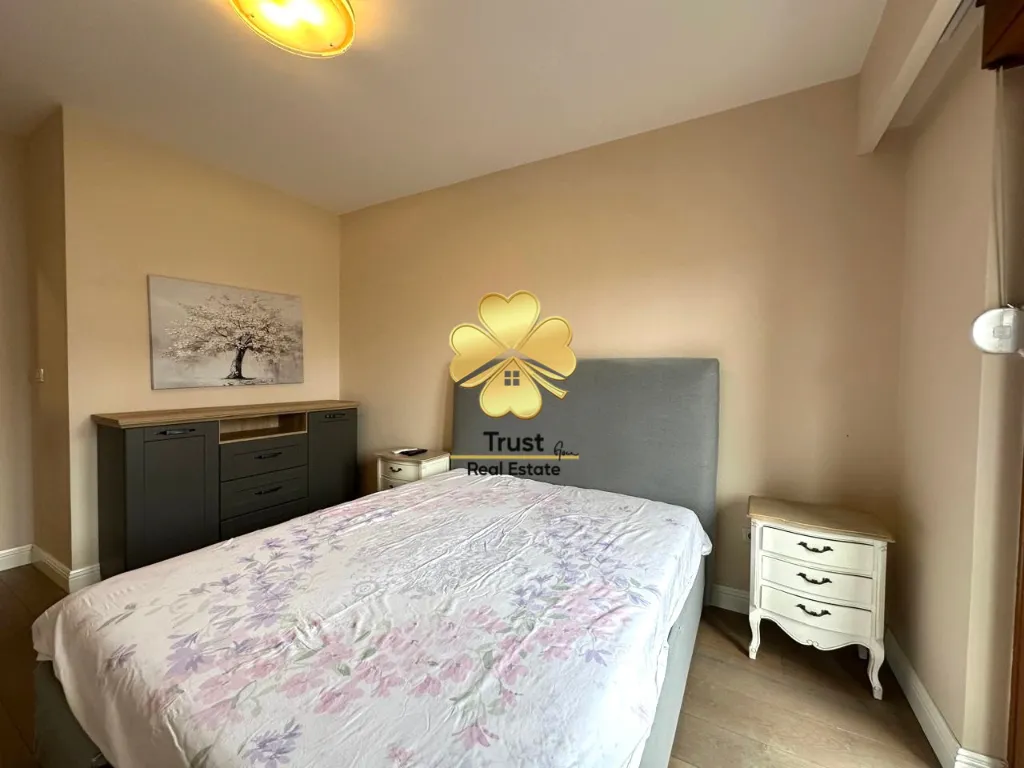 Furnished bedroom with a double bed, dresser, and a nightstand.