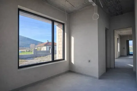 Prostorija u sivoj fazi izgradnje sa velikim prozorom i pogledom na prirodu. - image 5