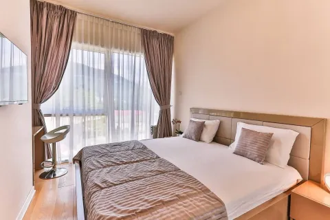 Furnished bedroom with a large double bed and a window. - image 6
