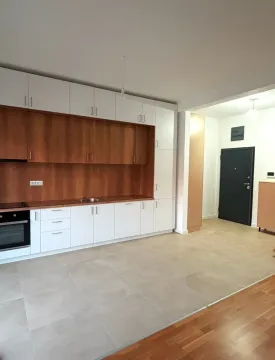 Moderna kuhinja sa bijelim i drvenim elementima u novom stanu. - image 2