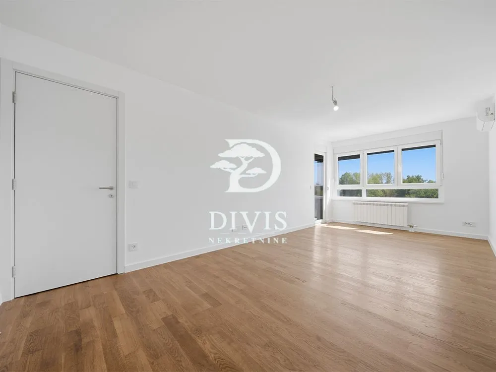 Empty bright room with parquet flooring and white walls.