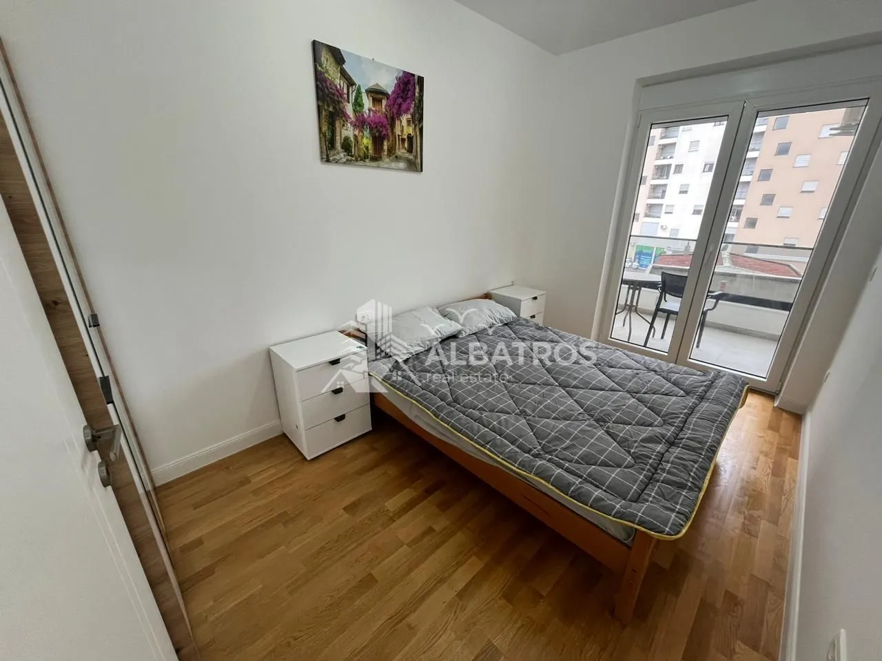 Bedroom with a double bed, bedside table, and access to the terrace.