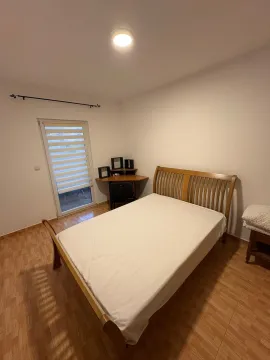 Bedroom with a double bed, a desk, and balcony doors. - image 8