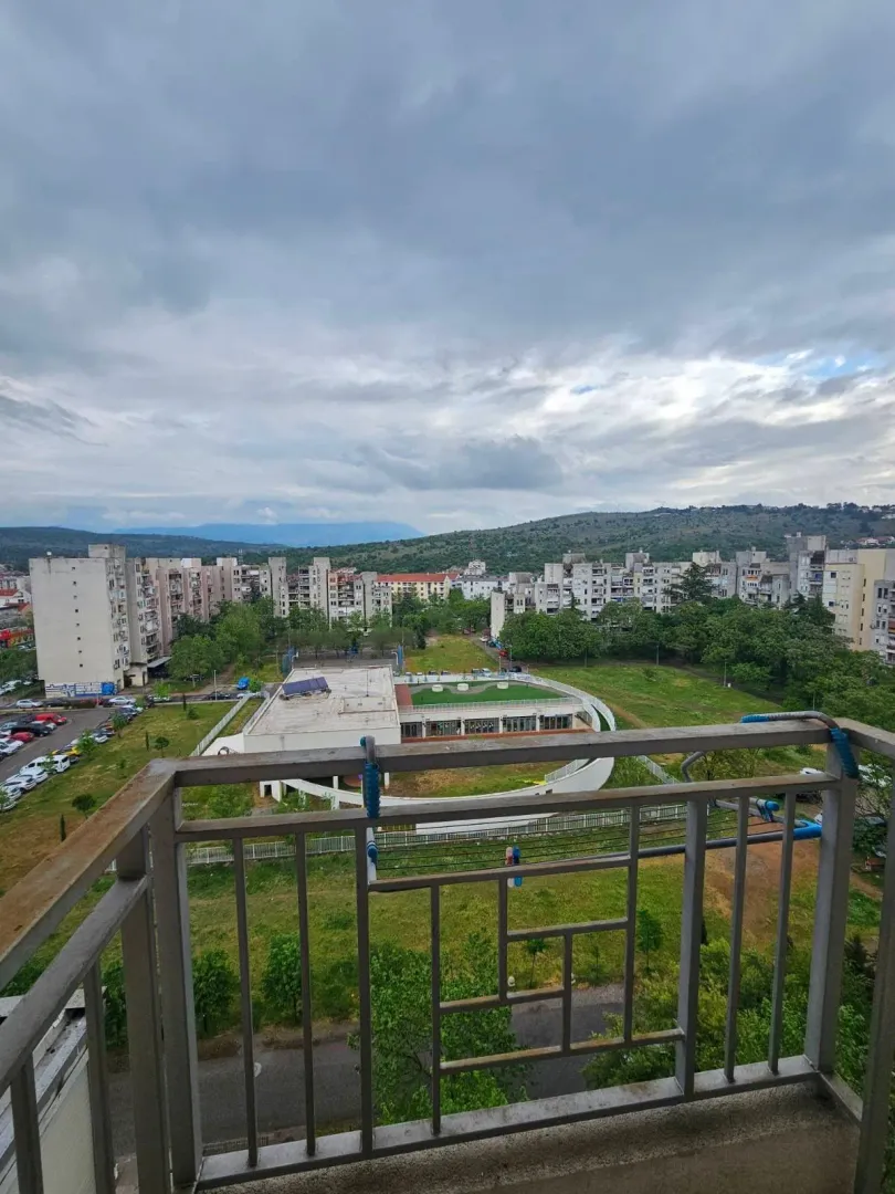 Pogled sa balkona na naselje i okolno zelenilo.