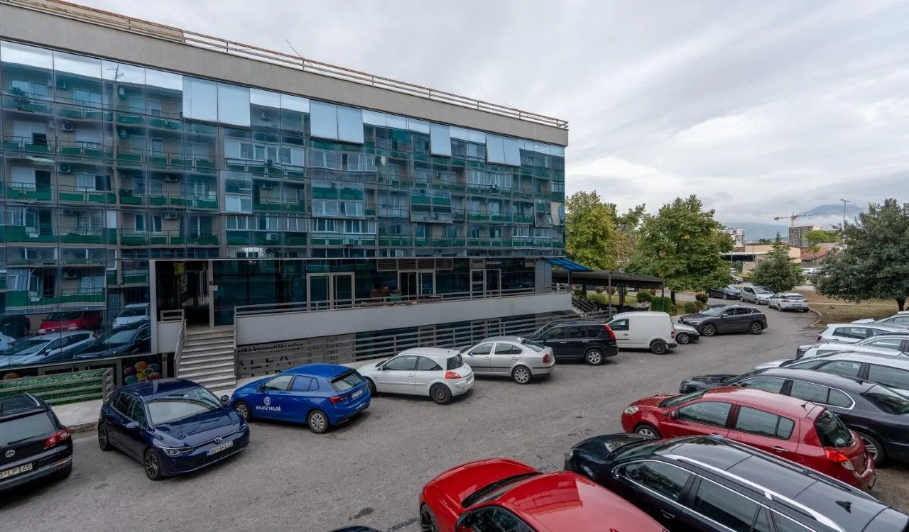 View of the exterior of the building with a parking lot and surrounding greenery.