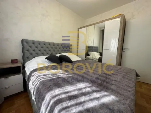 Nameštena spavaća soba sa bračnim krevetom i velikim ormarom sa ogledalom. - image 4