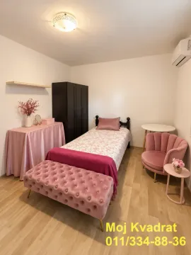 Spavaća soba sa krevetom, garderoberom i roze foteljom. - image 7