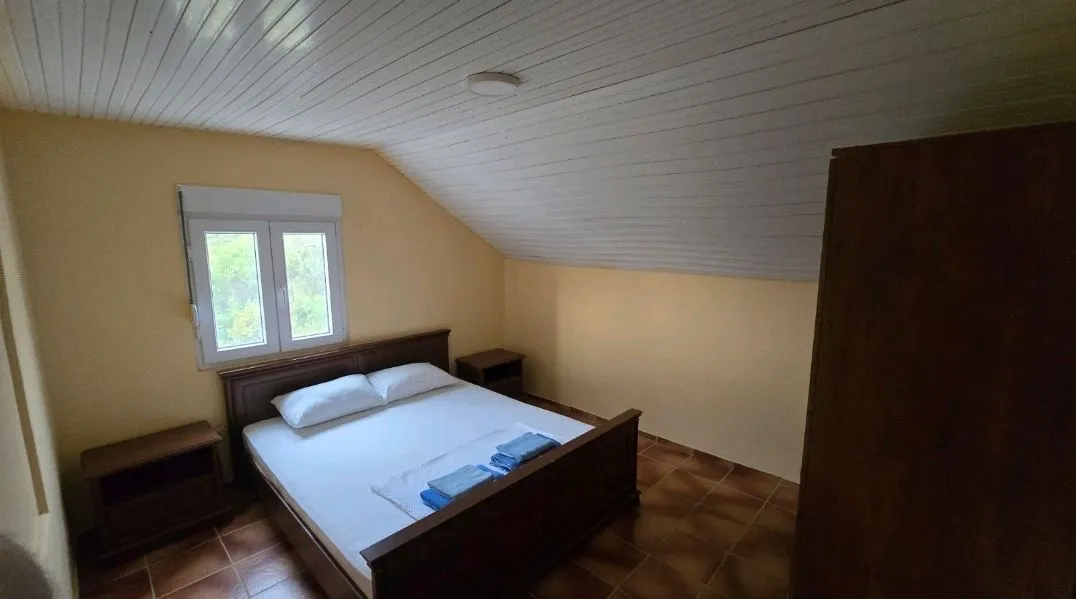 Furnished bedroom with a double bed, wardrobe, and sloping ceilings.