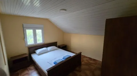 Furnished bedroom with a double bed, wardrobe, and sloping ceilings. - image 10