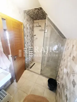 Bathroom with a walk-in shower and ceramic tiles. - image 8