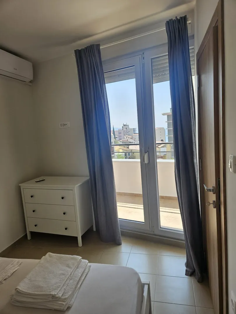 Bedroom with a bed, chest of drawers, and access to the terrace.