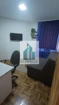 Manja dnevna soba sa kaučem, radnim stolom i televizorom na zidu. - image 11