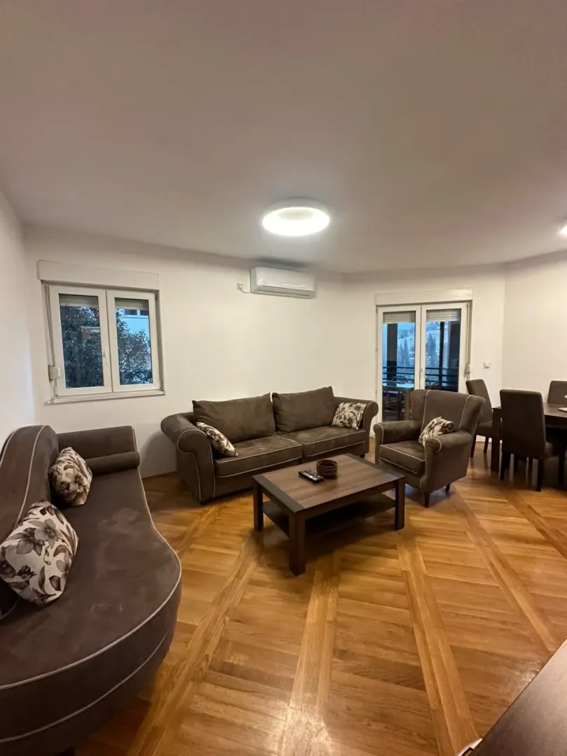 Living room with a sofa set, coffee table, and wooden parquet flooring.