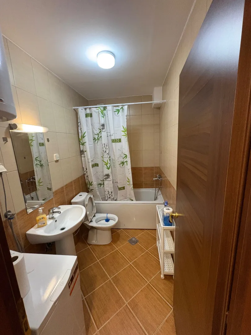 Manje kupatilo sa umivaonikom, wc šoljom, kadom i mašinom za veš.