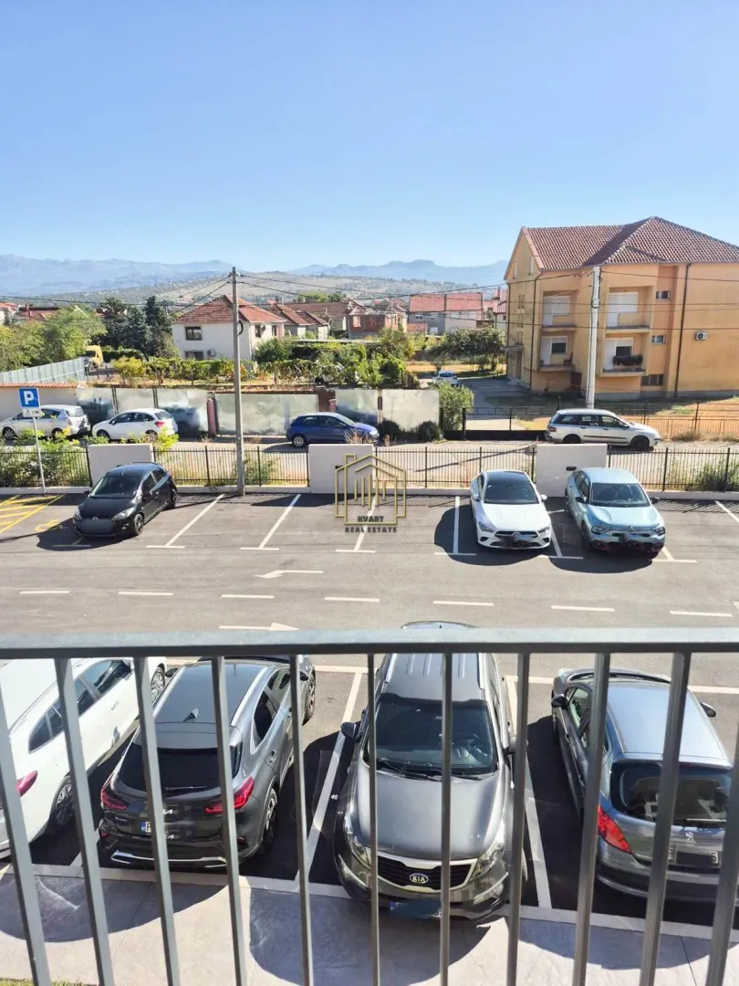 Pogled sa terase na parking i okolne zgrade.