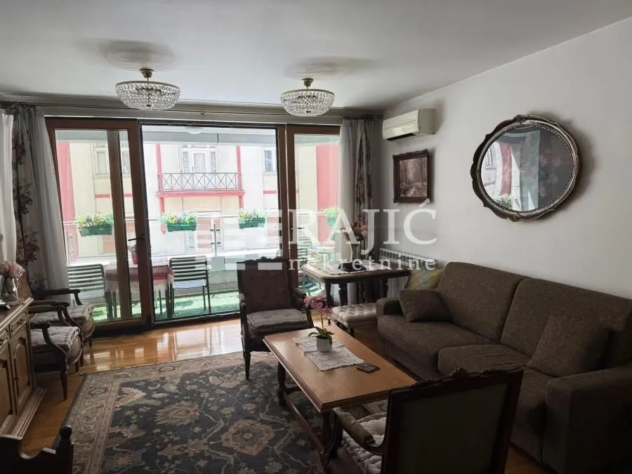 Living room with a sofa set, wooden coffee table, and access to the terrace.