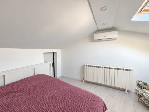 Attic bedroom with a double bed, air conditioning, and a skylight. - image 10