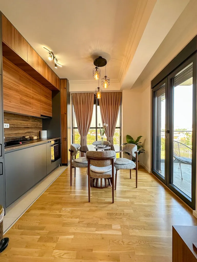 Modern kitchen with dining area and wooden flooring.