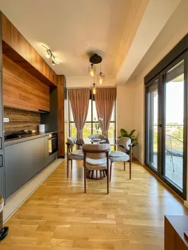 Modern kitchen with dining area and wooden flooring. - image 4