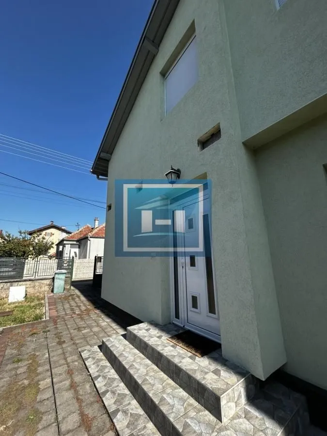 Ulaz u kuću sa stepeništem i popločanim dvorištem.